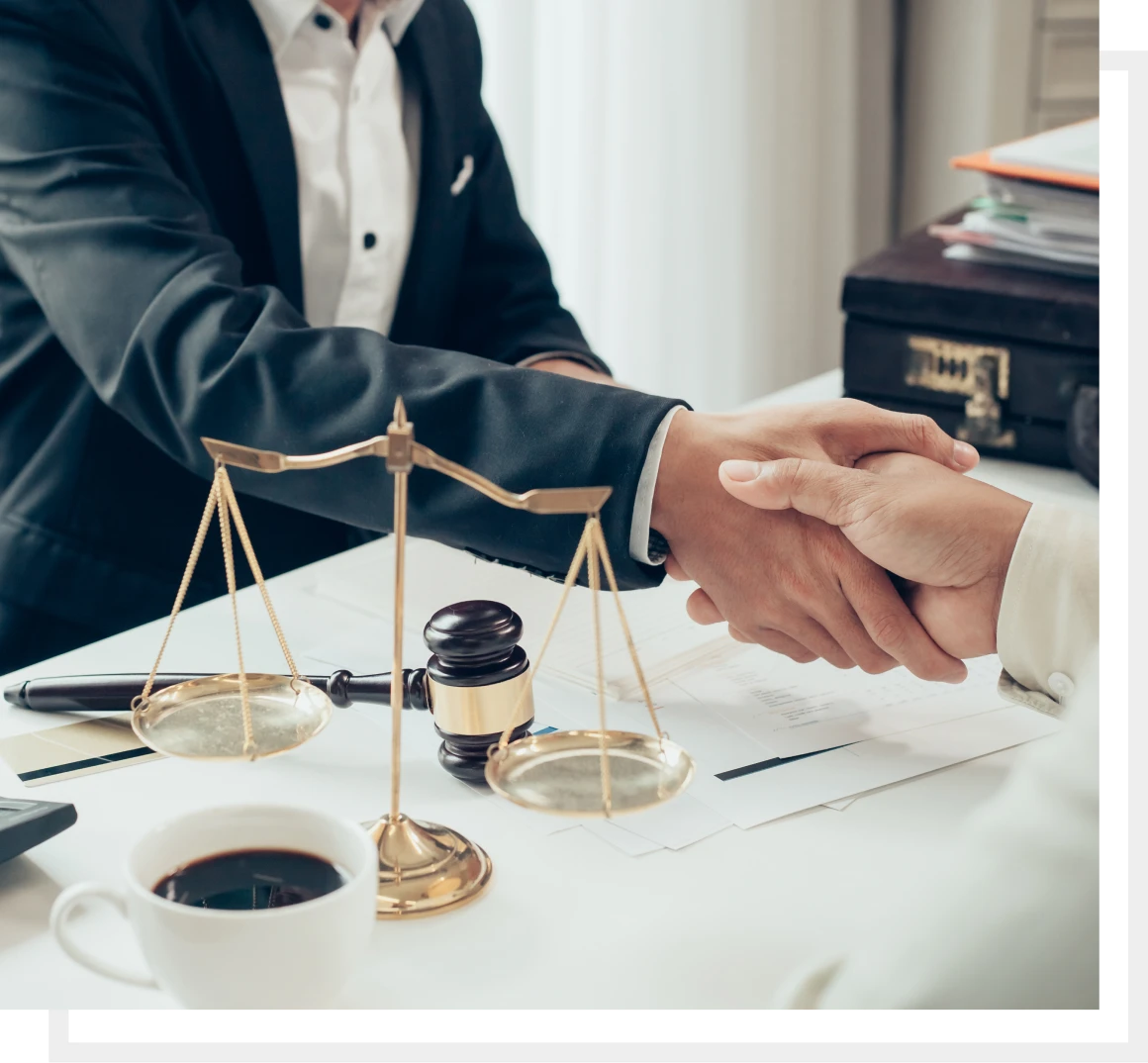 Lawyers shaking hands over legal documents