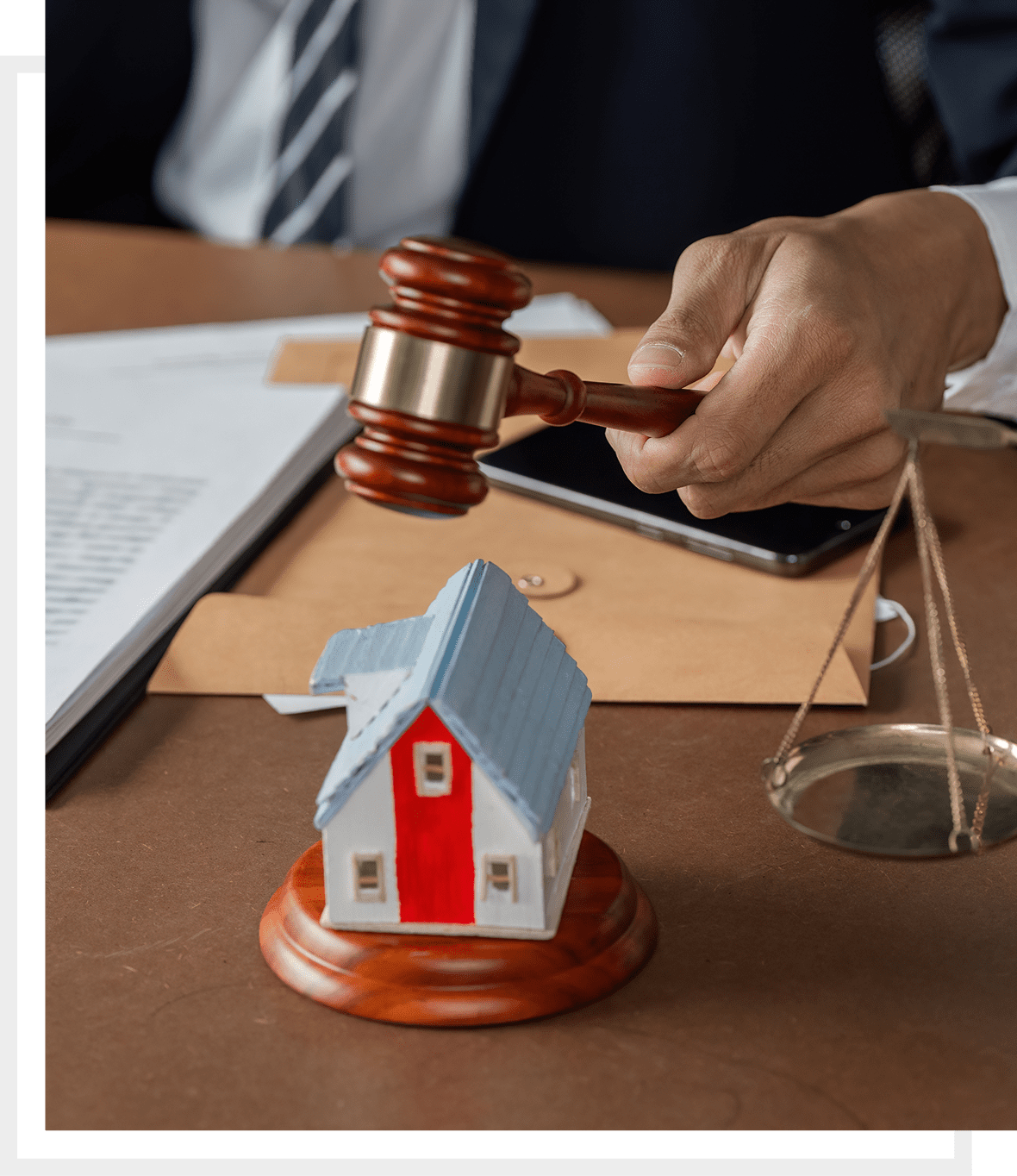 Lawyer holding gavel near model house