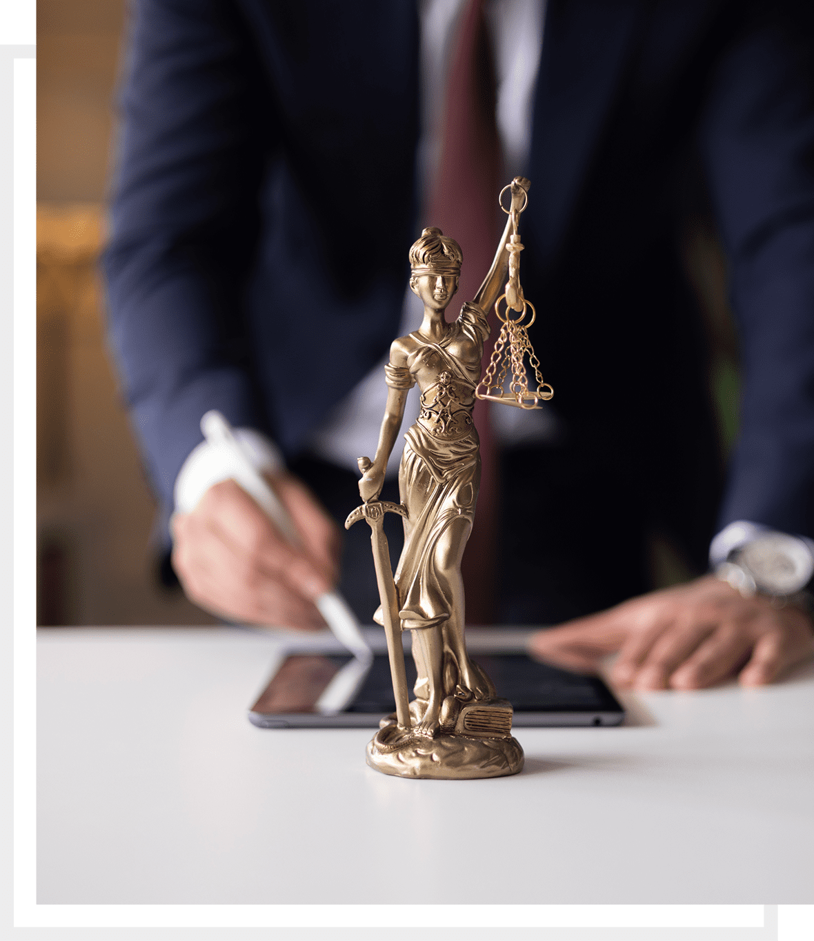 Lawyer writing behind justice statue